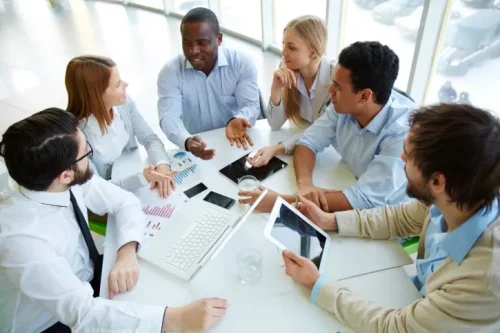 This image illustrates active collaboration among professionals, essential for structuring and effectively deploying a societal engagement plan aimed at maximizing territorial impact.