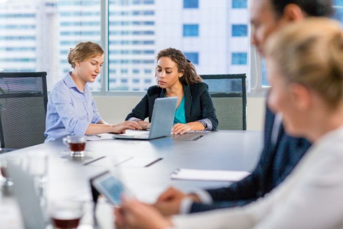 Des professionnels en réunion dans une salle moderne, illustrant les enjeux de recrutement dans le secteur numérique.