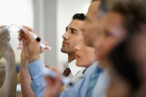 Consultants writing on a whiteboard during a study on the impacts of digital transformation on a telecom operator