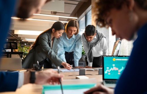 Focused professionals collaborate over financial documents in a modern office, illustrating KYC data analysis.