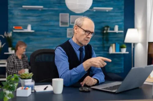 Senior man working on a computer in a modern office, illustrating the thinking process behind digital customer experience personalization.