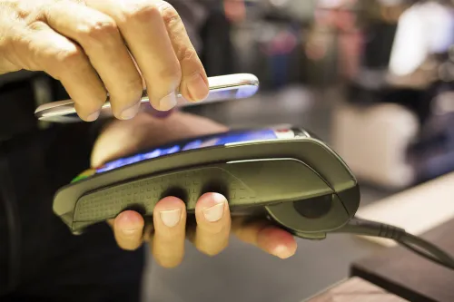 Contactless payment via smartphone, illustrating the rise of mobile money and digital payments.