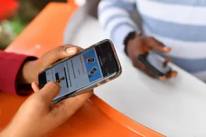 Main utilisant un smartphone pour accéder à un service de mobile money au Moyen-Orient