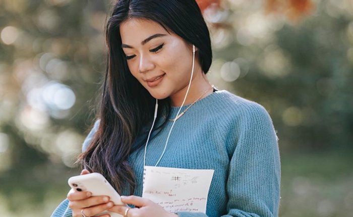 Young woman using a smartphone, illustrating mobile connectivity and self-optimizing networks

