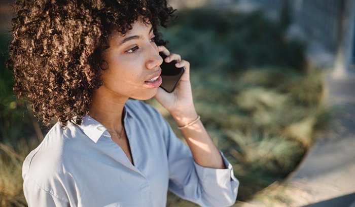 Femme en communication téléphonique, illustrant la connectivité mobile et la virtualisation des réseaux.